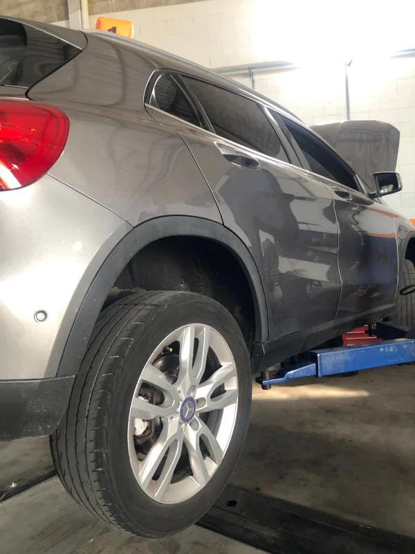 Veículo SUV elevado no elevador automotivo durante procedimento de revisão
